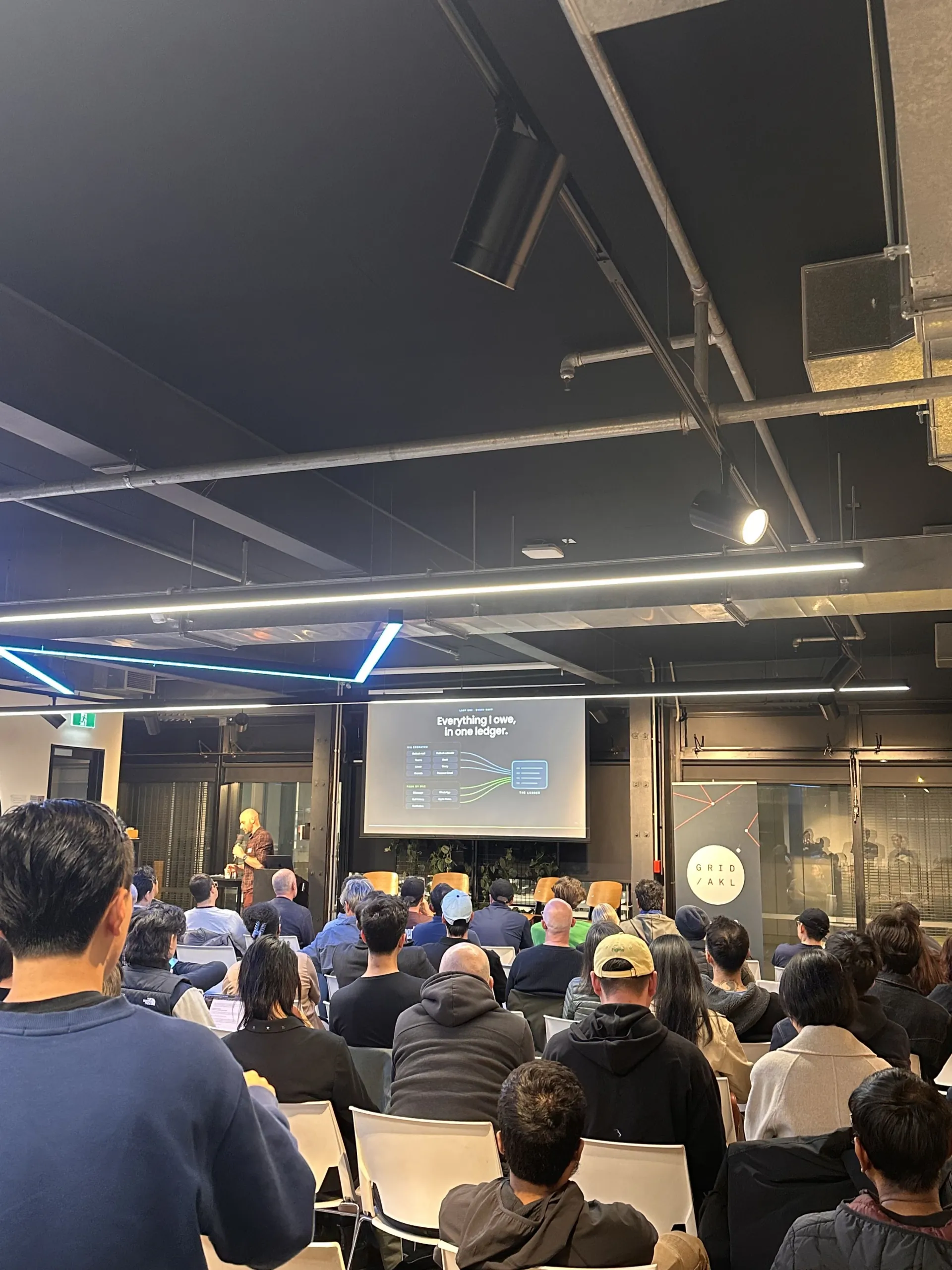 Speaker presenting next to the GridAKL banner