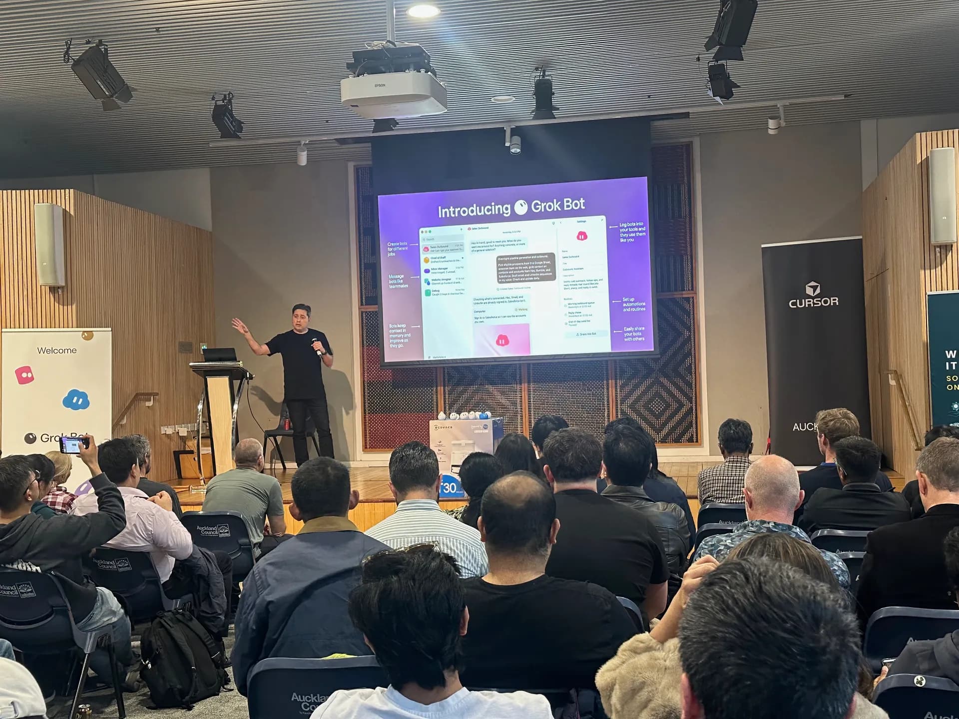 Introducing Grok Bot slide on the big screen in front of a full room