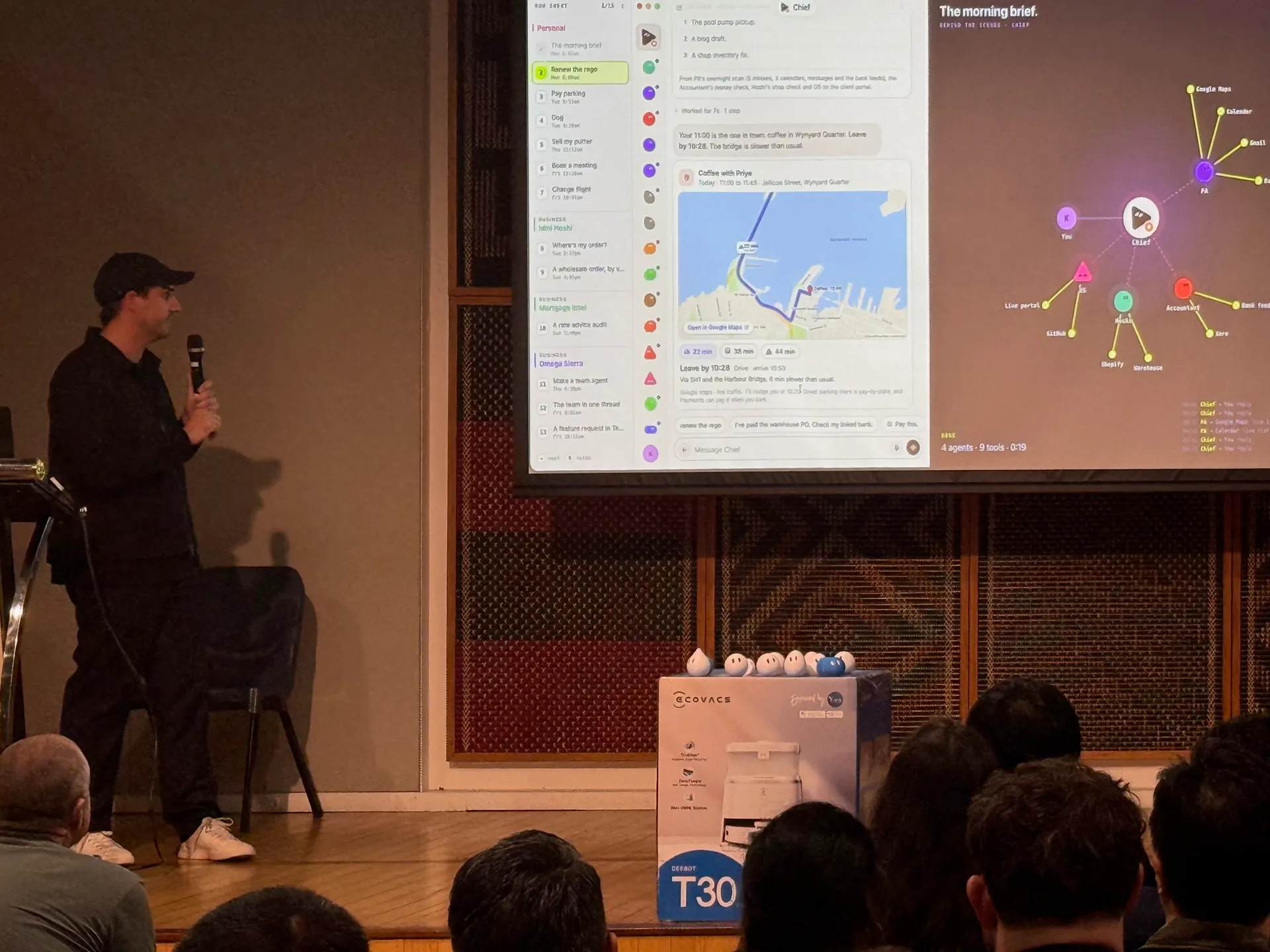 Speaker gesturing at a live demo with a chat panel and node graph