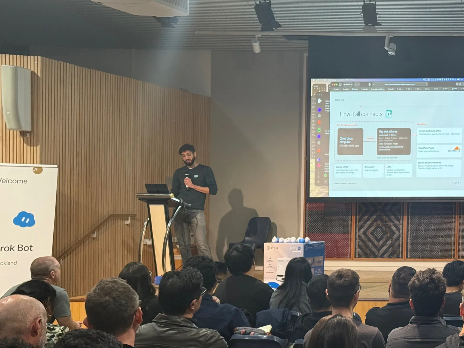 Speaker with the How it all connects diagram on screen behind him