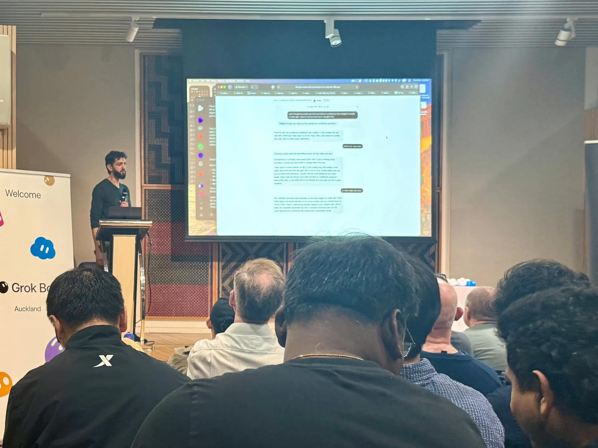 Speaker at the lectern during a live demo, seen over the audience