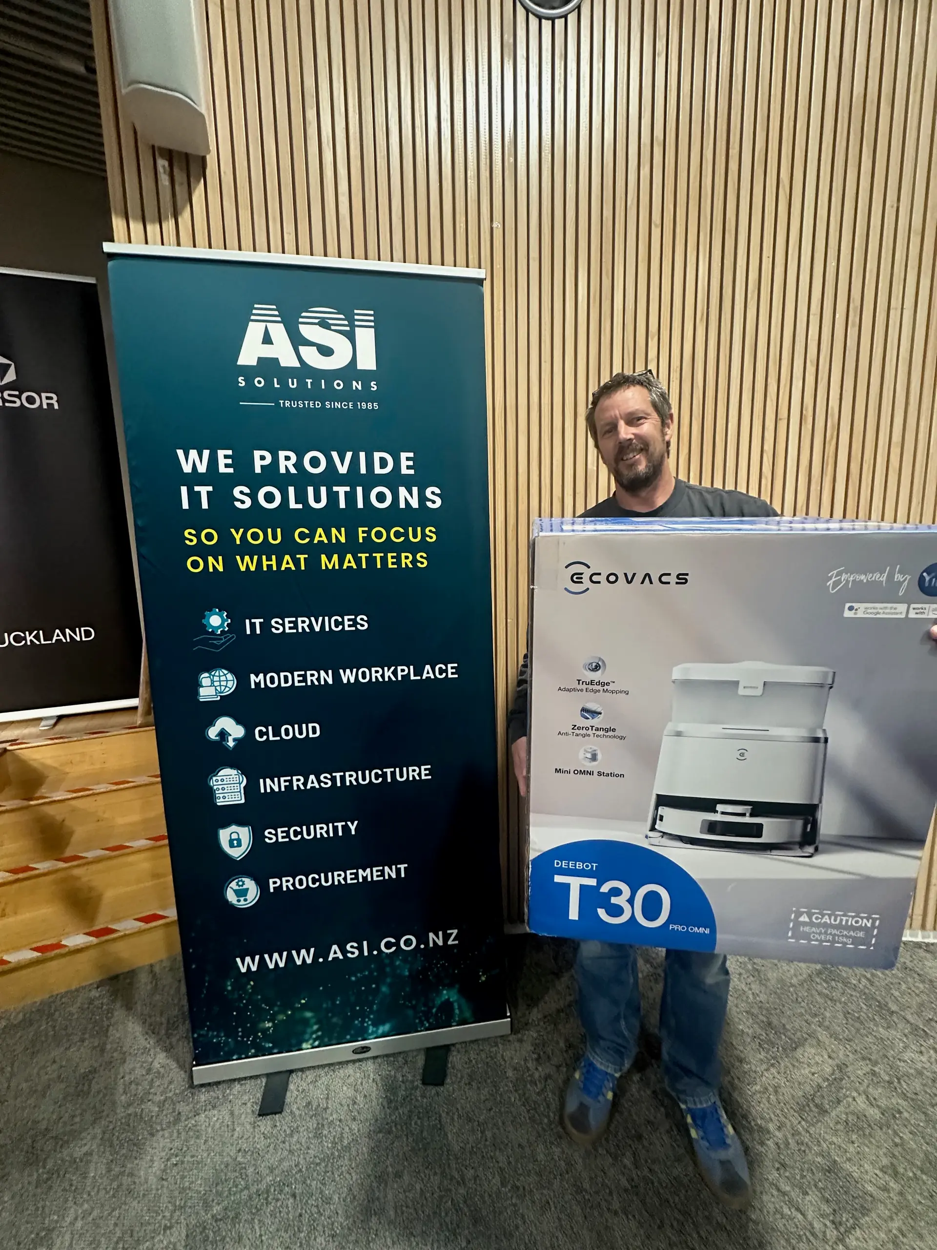 Kahoot winner posing with the ASI-sponsored robot vacuum