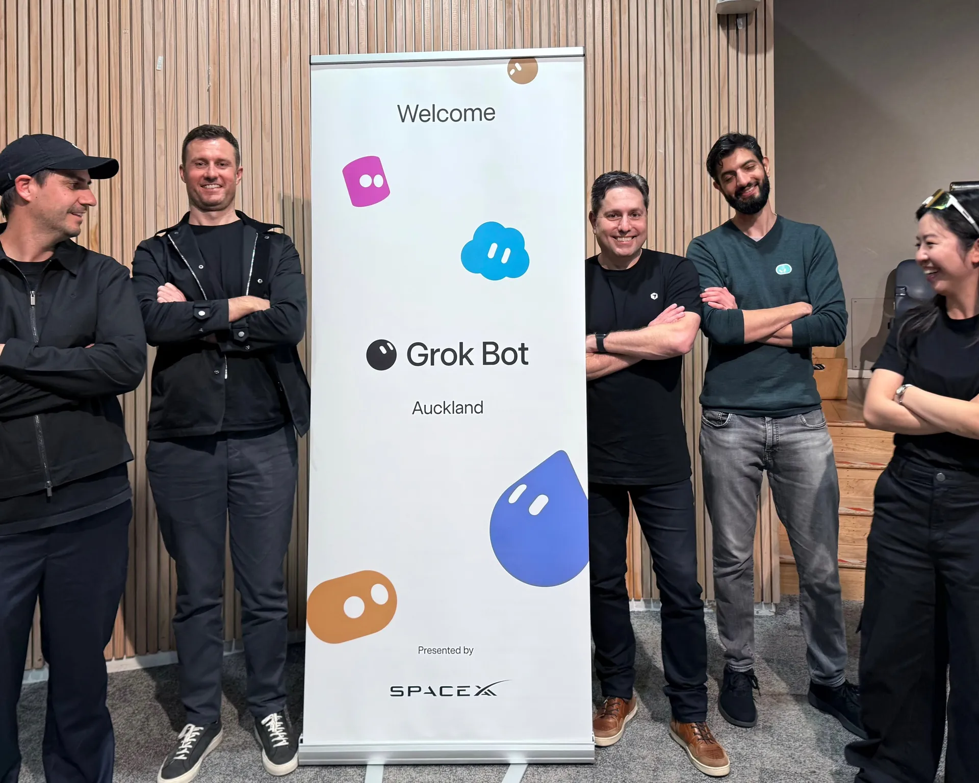 Team photo either side of the Grok Bot Auckland welcome banner